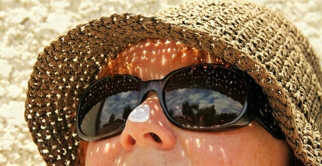  ett kvinnoansikte med solglasögon och hatt