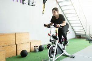  kvinna tränar på en stationär cykel