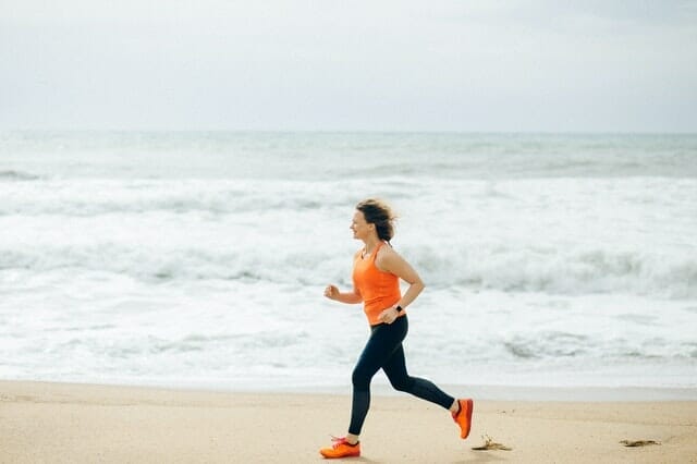  kvinna springer på stranden