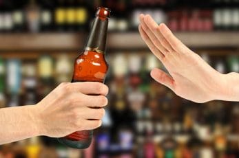  handen håller flaskan med alkohol i handen